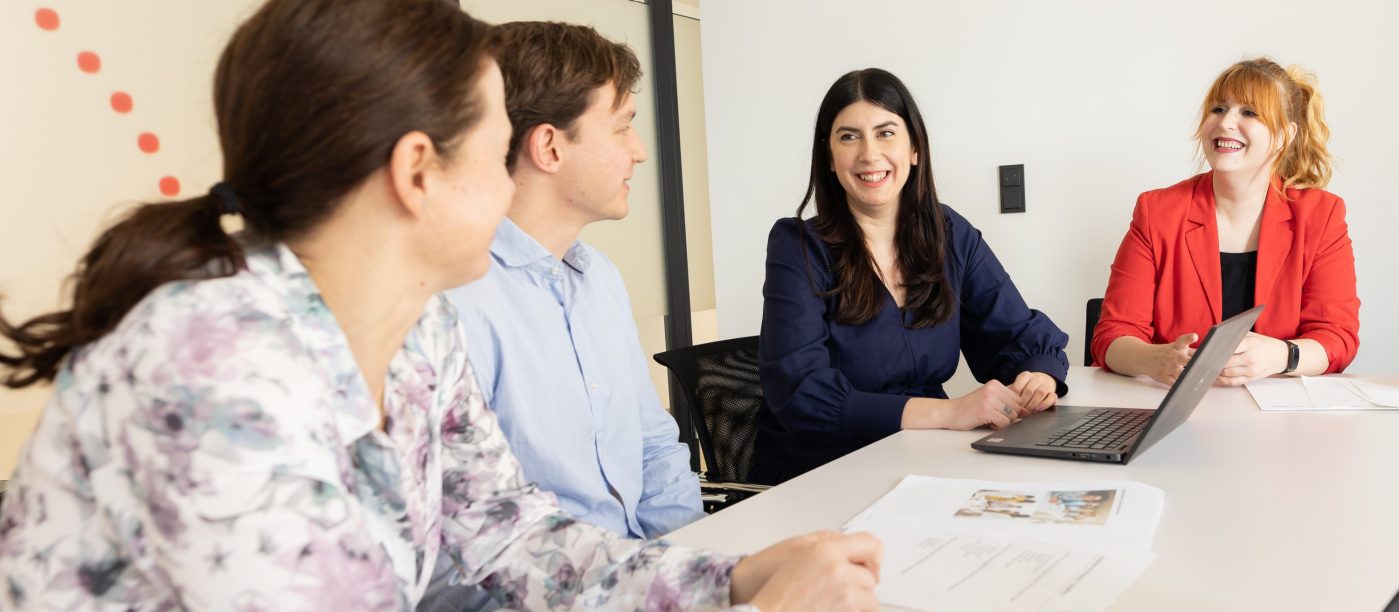 People in a meeting room, smiling