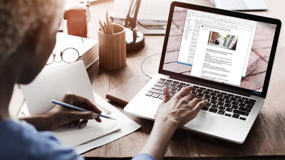 laptop, Woman typing with one hand, pencil in the left hand