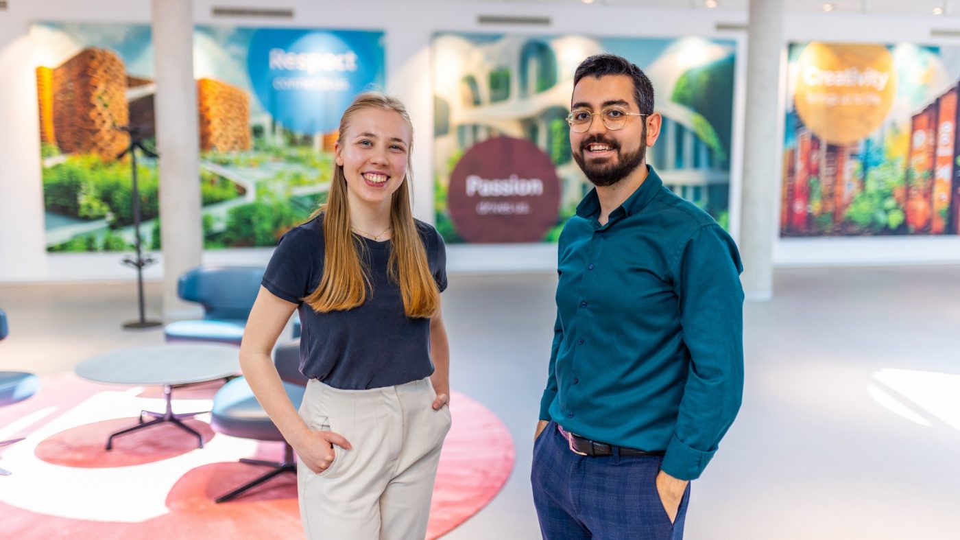 Two people smiling into camera, lobby